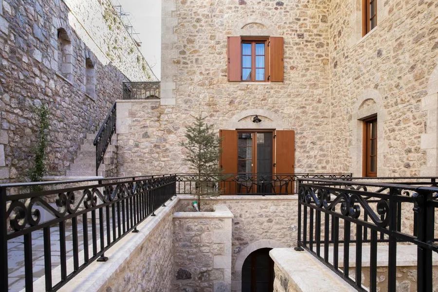 Η πέτρινη αυλή με τα σιδερένια κάγκελα